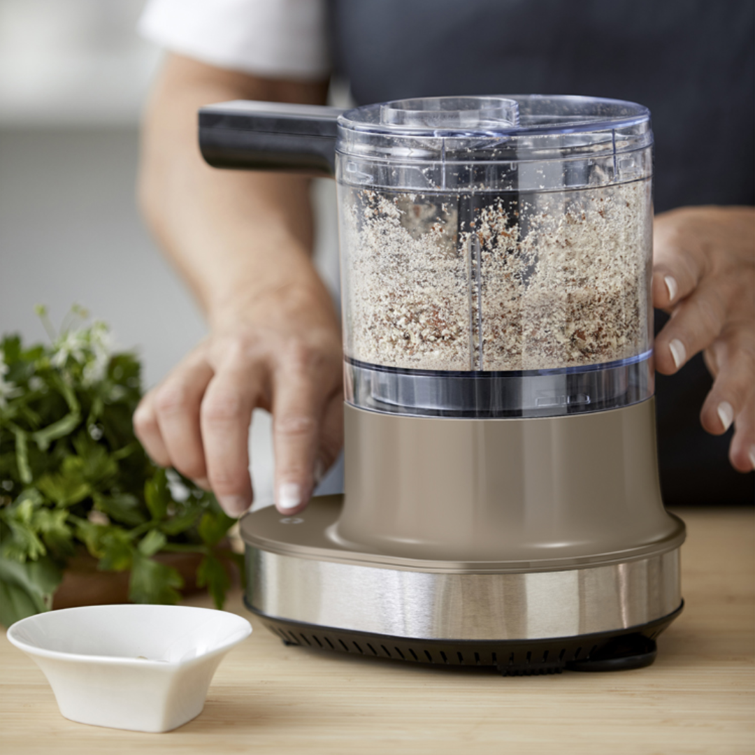 Blomsterbergs multihakker i latte og stål med klar 600 ml beholder fyldt med hakkede ingredienser