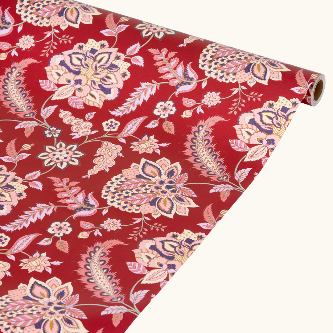 Rød gavepapirrulle med blomstret paisley-mønster i pink, creme og navy