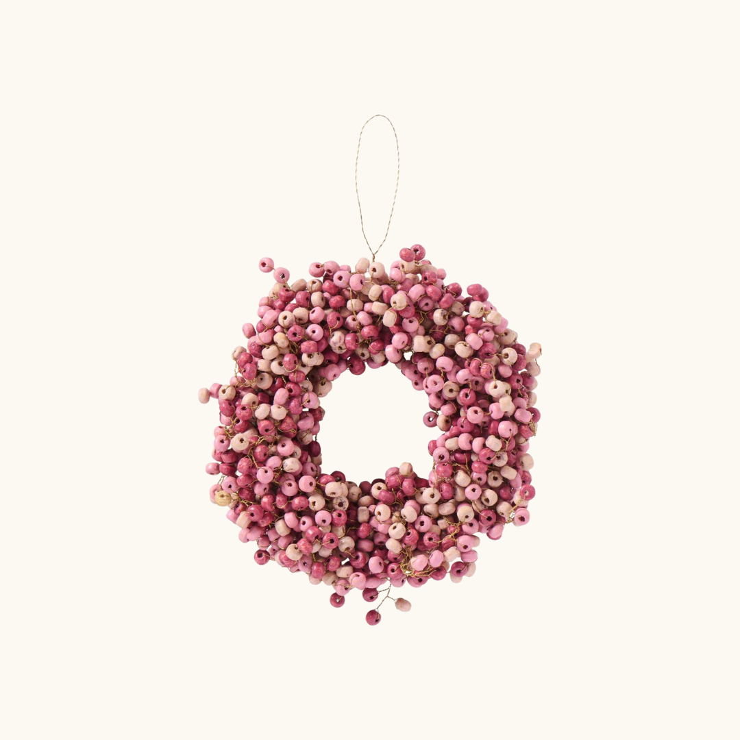 Rund krans af små rosa træperler i forskellige nuancer med ophængstråd