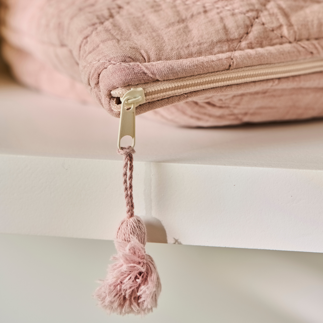 Quiltet toilettaske i rosa bomuld med lynlås og pink kvast som lynlåstræk
