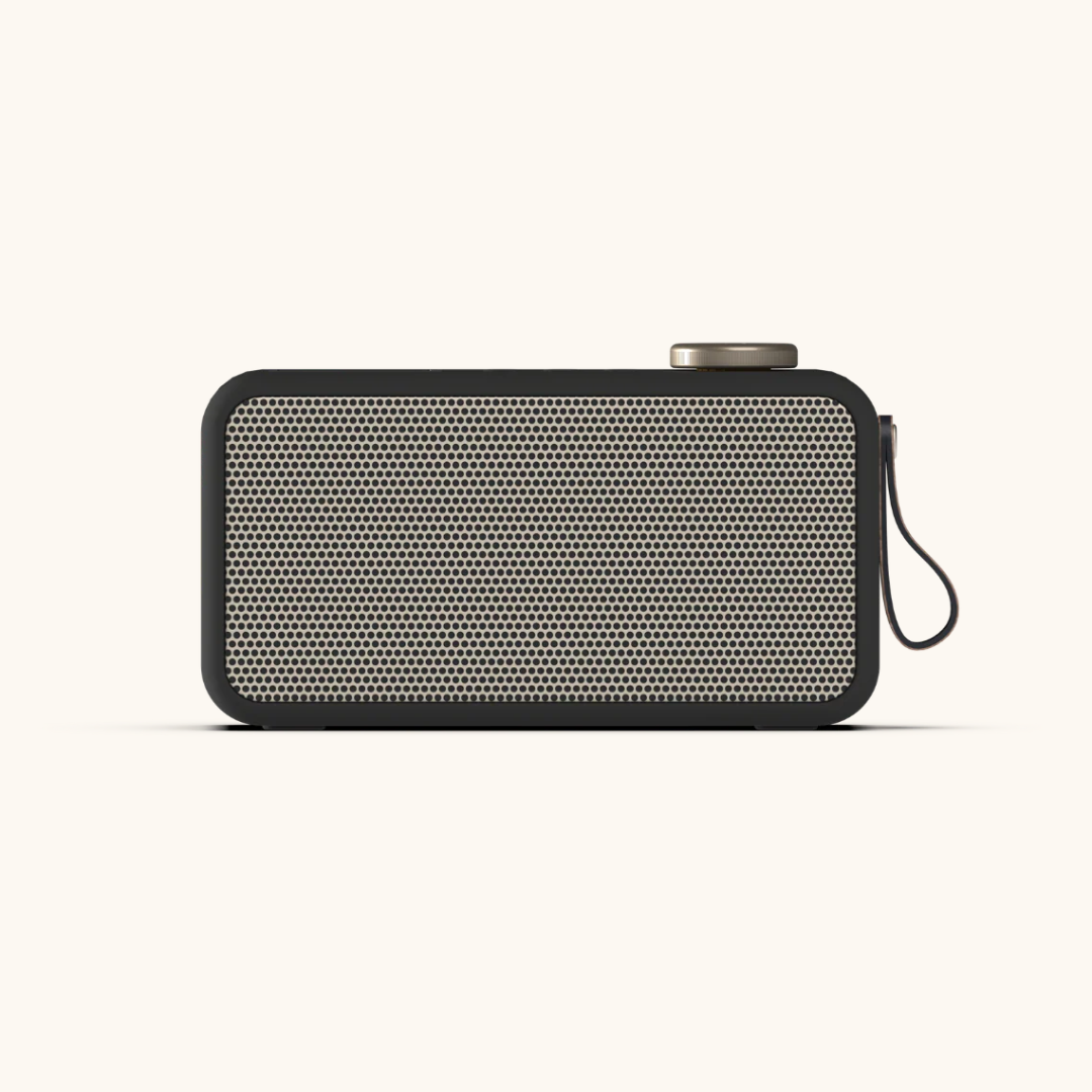 Sort DAB+ radio med beige perforeret front, metalknap øverst og bærerem på siden