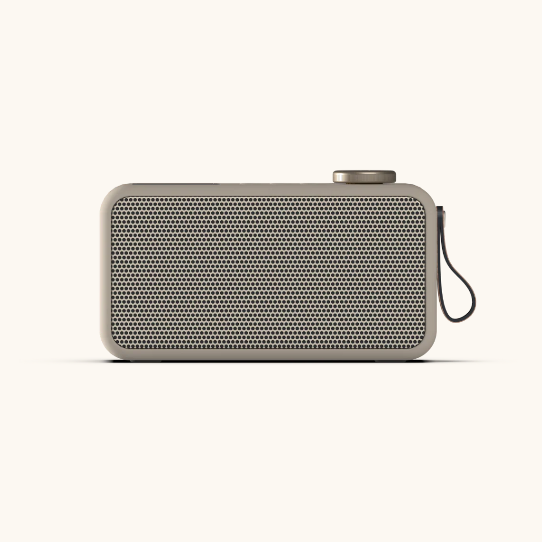 Beige DAB+ radio med perforeret frontgitter, metalknap øverst og sort håndledsrem