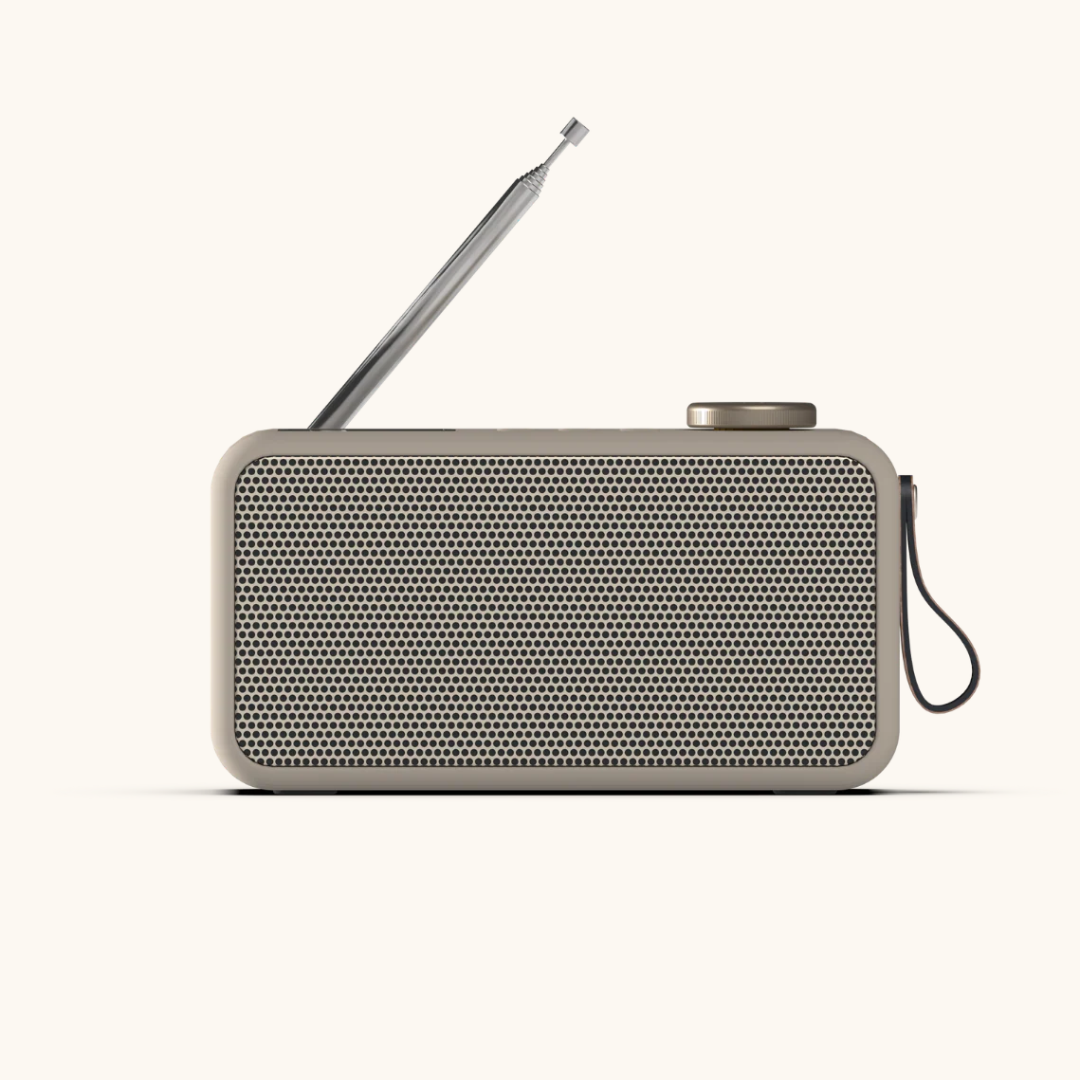 Beige DAB+ radio med perforeret front, udtrukket antenne, drejeknap og bærerem