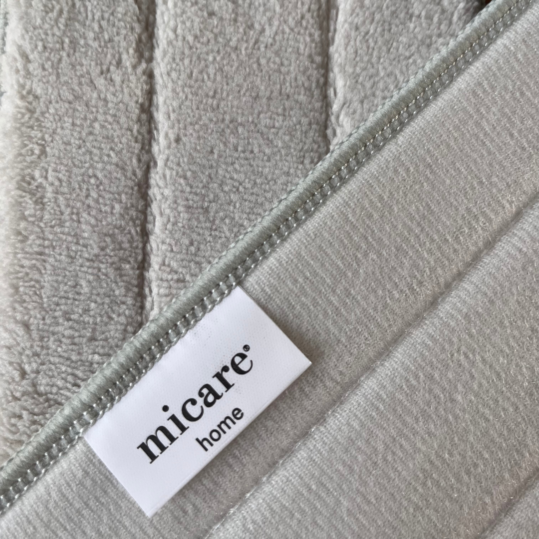 Lysegrå moppe med frotté-overflade og Micare Home-label ved syet kant