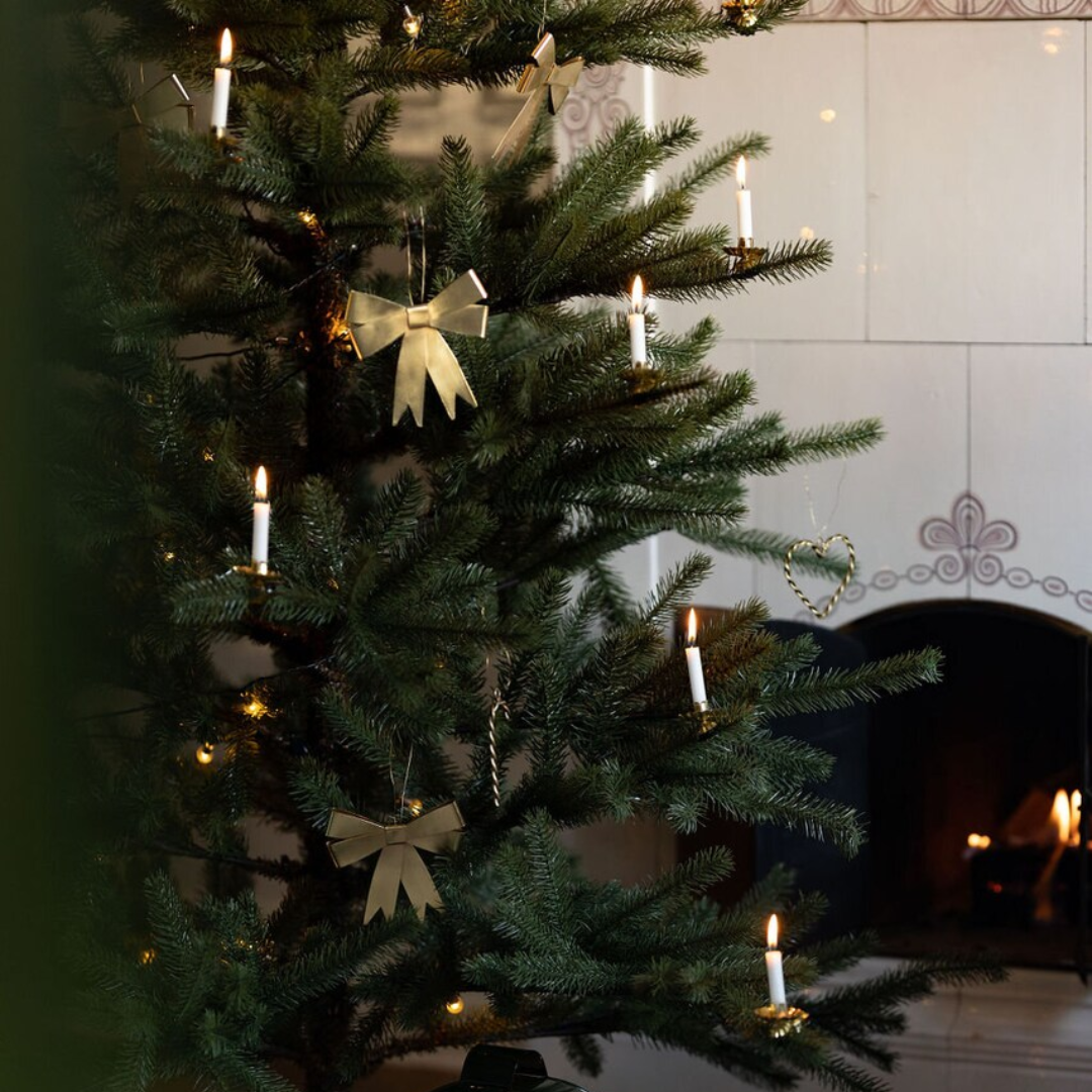 Sløjfeformet juleophæng i antik messing hængt på grønt juletræ