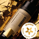 Humdakin skospray 2-i-1 300 ml i hvid flaske med sort pumpe og sort låg, omgivet af gyldne konfetti-stykker
