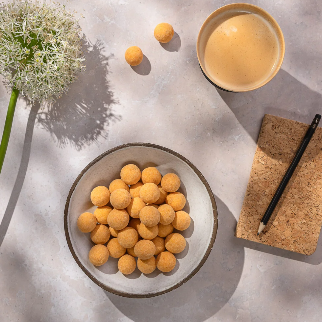Gyldne mango passion chokoladebolde i keramikskål