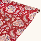 Rød gavepapirrulle med blomstret paisley-mønster i pink, creme og navy