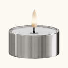 Rundt LED fyrfadslys med sølv metalholder og hvid flamme tændt