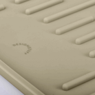 Sandfarvet foldbar silikone opvaskebakke med parallelle ribber og præget Designstuff-logo