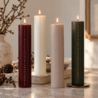 Fire tændte kalenderlys i mørkerød, ivory, beige og mørkegrøn med guldfarvede tal 1-24