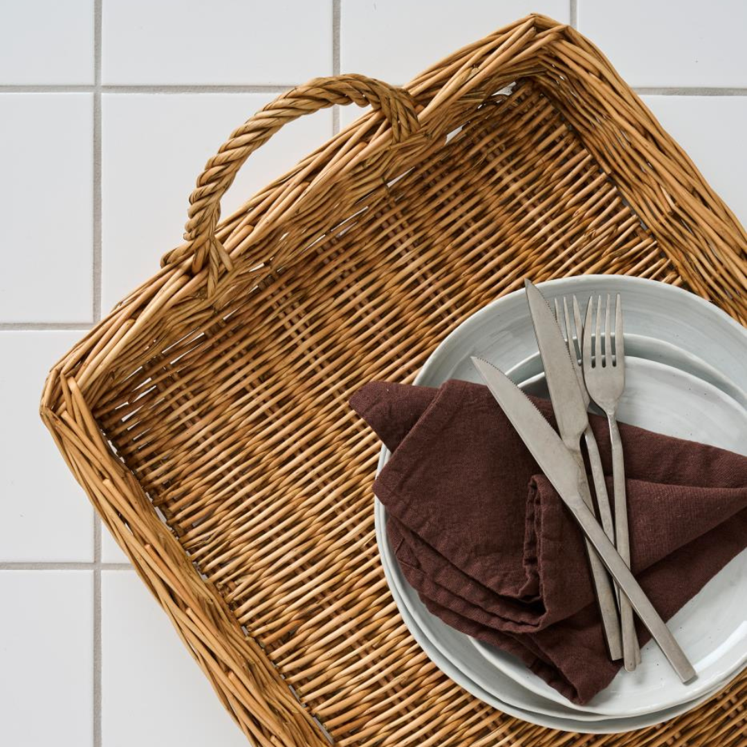 Aflang pileflet bakke i natur med to hanke og hvide tallerkener med brun serviet
