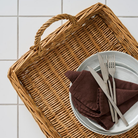 Aflang pileflet bakke i natur med to hanke og hvide tallerkener med brun serviet