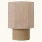 Lille bordlampe med hørfarvet cementfod og rund tekstilskærm i beige
