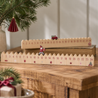 To naturfarvet MDF julekalendere med tal 1-24 og røde julemotiver, en med nisse og en med ladbil