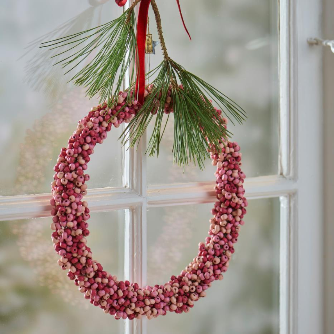 Rund julekrans af små rosa træperler i mangotræ med grønne nålegrene