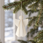 Hvid 3D papirengel med foldede vinger og rund halo, hængt op i juletræ
