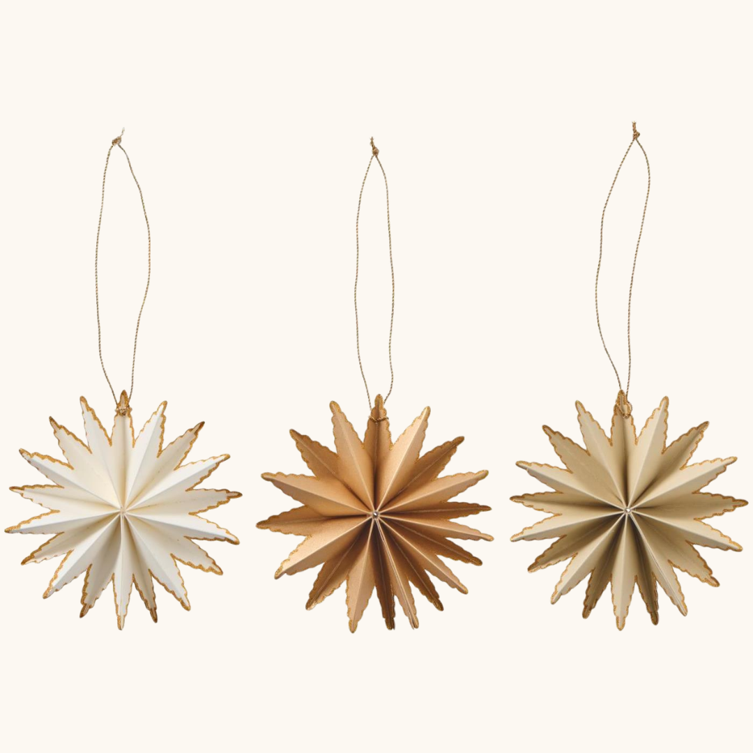 Tre foldede papirstjerner i hvid, guld og beige med guldkanter og snor til ophæng