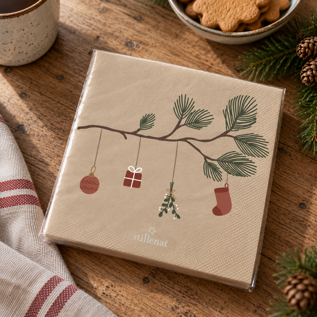 Beige papirservietter med julemotiv af gran-gren med kugle, gave, mistelten og strømpe