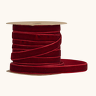 Bordeaux velourbånd i polyester på brun papspole, 1 cm bredt