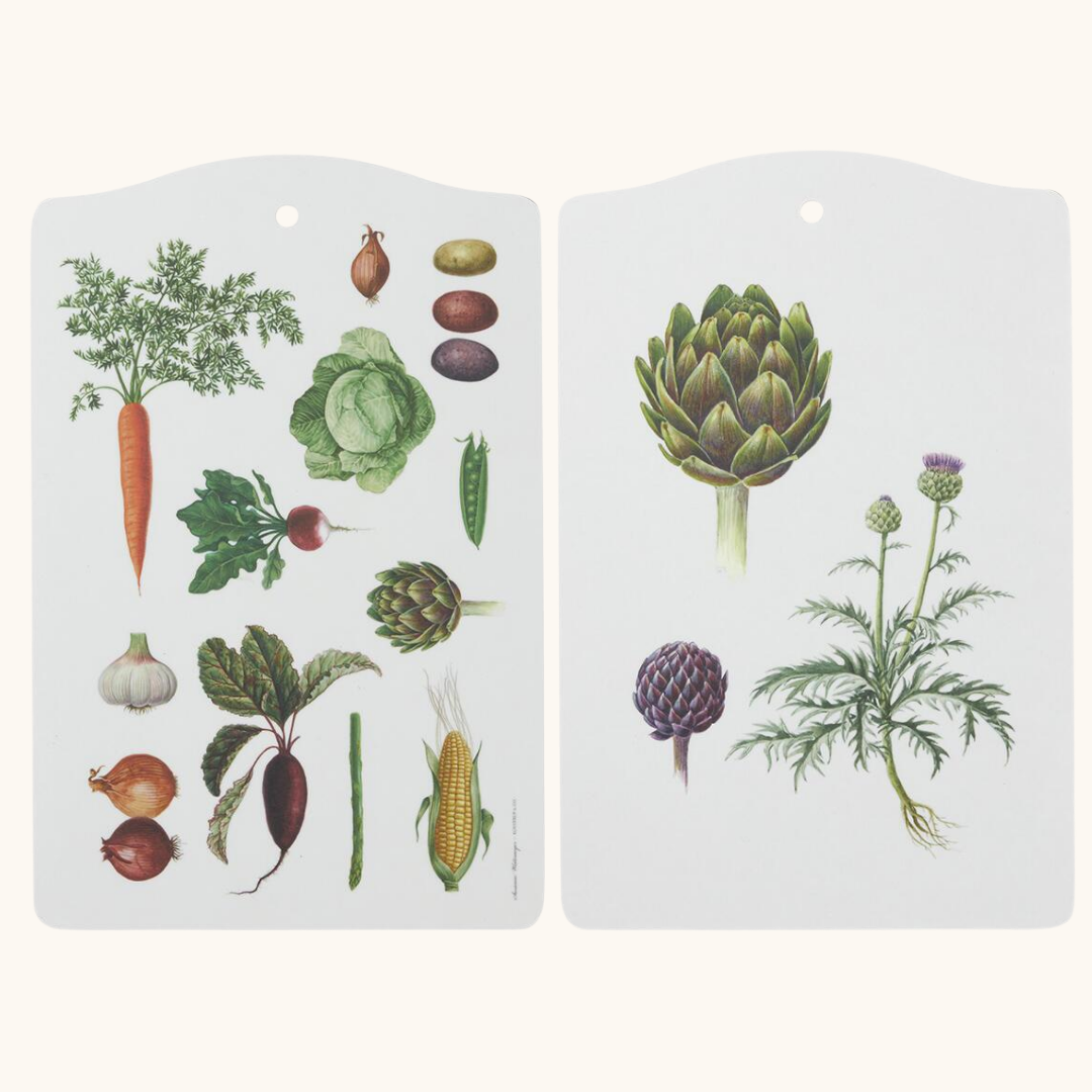 To hvide skærebrætter med botaniske grøntsagsillustationer – gulerod, artiskok, løg og majs