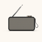 Sort DAB+ radio i retrodesign med beige perforeret front, udtrukket antenne og bæresnor