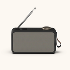 Sort DAB+ radio med beige metalnet, sølv antenne og brun læderrem