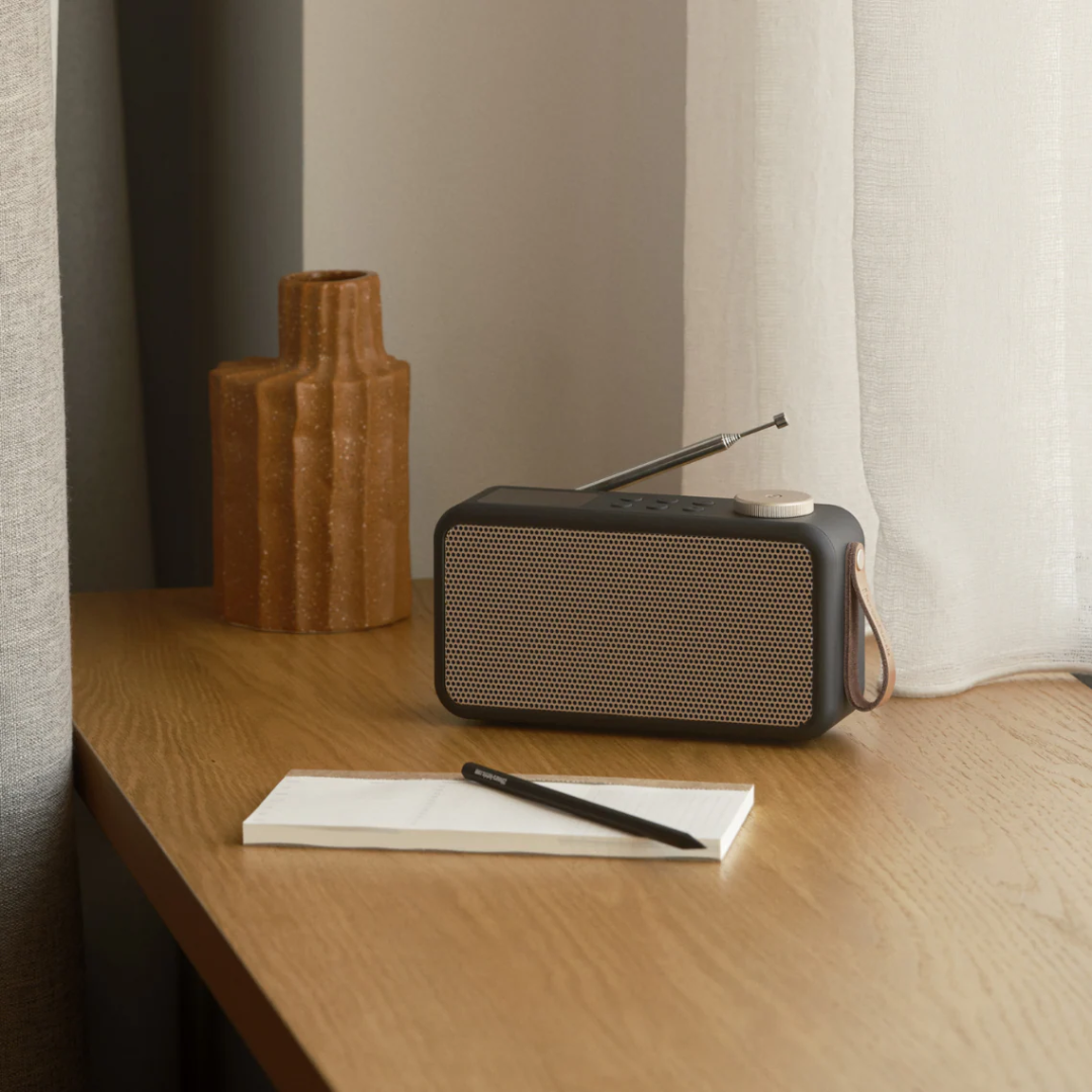 Mørkegrå DAB+ radio med gyldent højttalergitter, teleskopantenne og brun læderrem