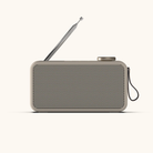 Beige DAB+ radio med perforeret front, udtrukket antenne, drejeknap og bærerem