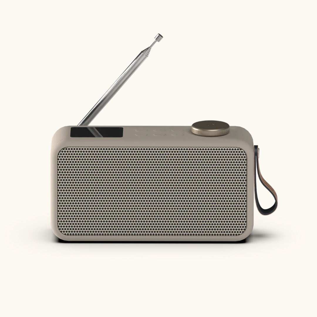 Kompakt DAB+ radio i beige med perforeret front, udtræksantenne og brun bærerem