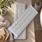 To lysegrønne/beige mopper med hvide kanter og micare toilet-label lagt ovenpå hinanden