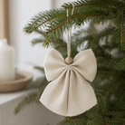 Offwhite juteengel med struktureret vævning og træperle, hængt op med snor i juletræ