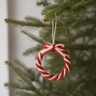 Rød og offwhite flettet jutekrans med sløjfe, hængt op i juletræ