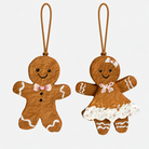 To brune papmaché honningkagefigurer med hvide detaljer og snor til ophæng